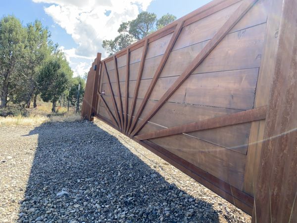 Custom wood and steel sunburst-pattern driveway gate by Mountain Valley Welding